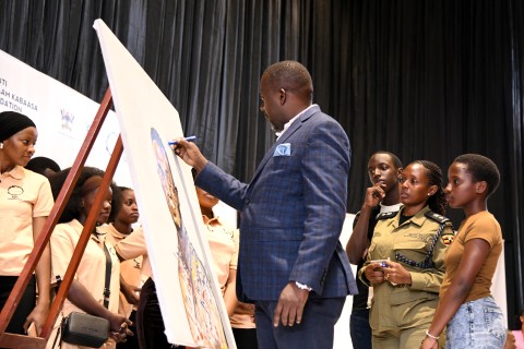 Mr. Yusuf Kiranda autographs the memorial art piece as Mrs. Pamela Kabaasa (2nd Right), her children and members of Hadithi Ya Mzizi witness on 29th August 2025. 3rd edition of Hadithi Ya Mzizi to celebrate the resilience and innovation of the informal sector through art exhibition and to memorialize its founder, the late Nshuti Balaam Kabaasa, 29th August 2025 Makerere University, Kampala Uganda, East Africa.